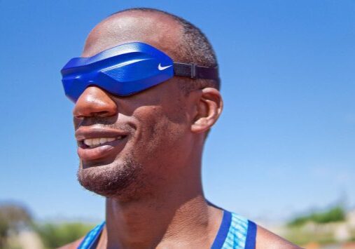 Athlete wearing blue Nike eye mask under a clear sky.